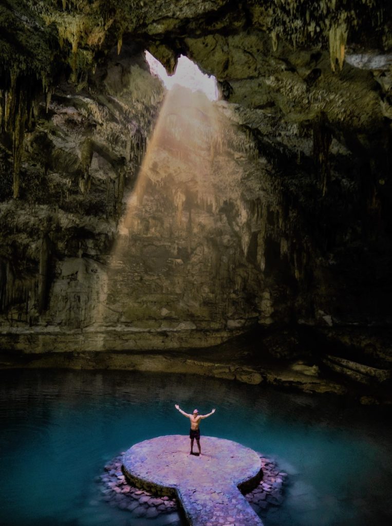 Homme levant les bras dans la grotte du Mexique