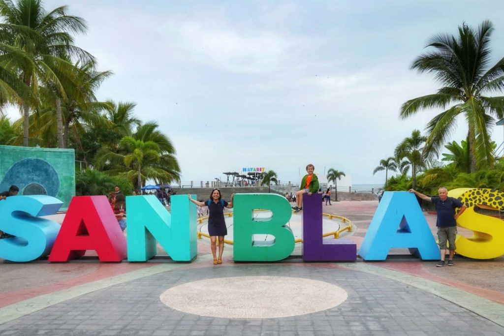 Jeune femme et enfant prenant une photo à côté des lettres colorées de San Blas, que faire riviera nayarit