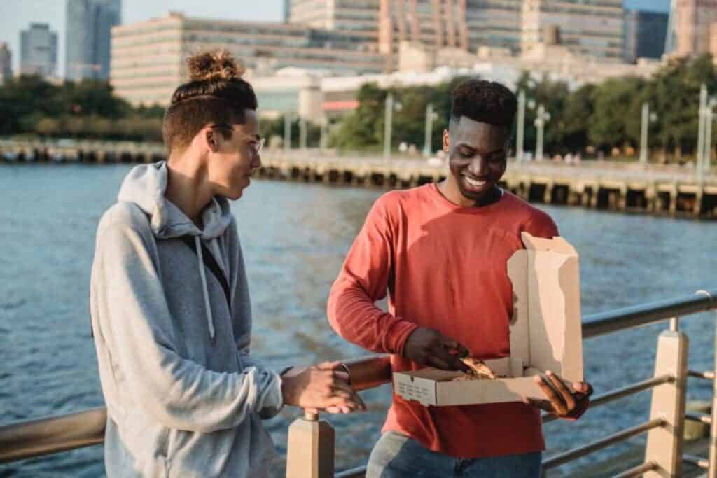deux amis qui se partagent une pizza aux États-Unis
